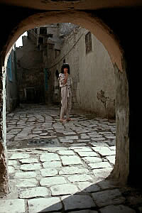 Anne standing in cobblestone alley
