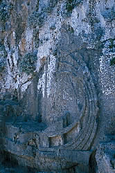 Carves ship on a stone wall